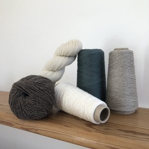 Cônes et pelotes de laine et de lin sur une étagère