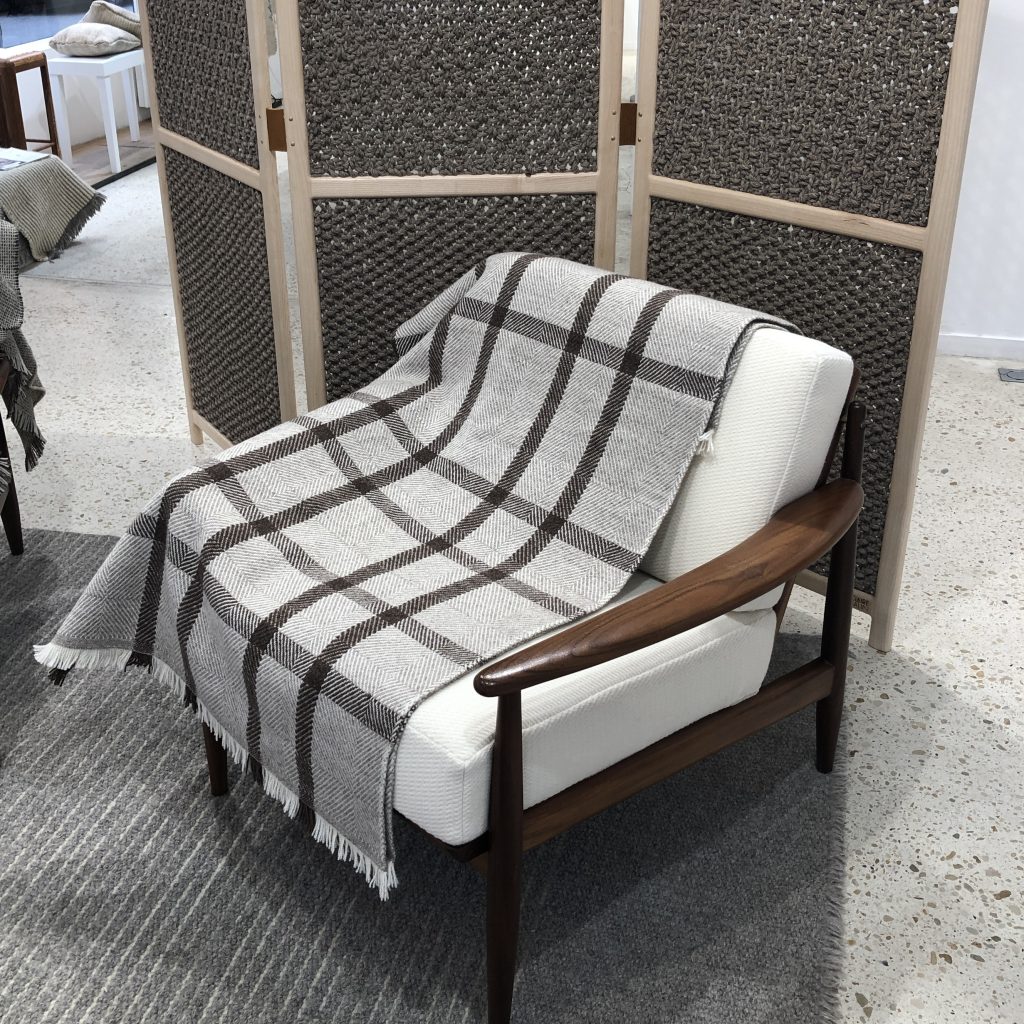 Plaid à carreaux en nuances de gris sur un fauteuil