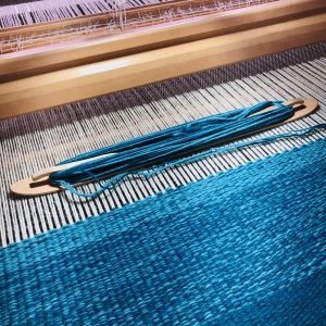 Tapis bleu en cours de tissage sur métier basse lisse